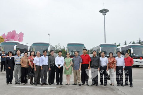 参加交车仪式的领导及文艺院团负责人在受赠的宇通客车前合影留念