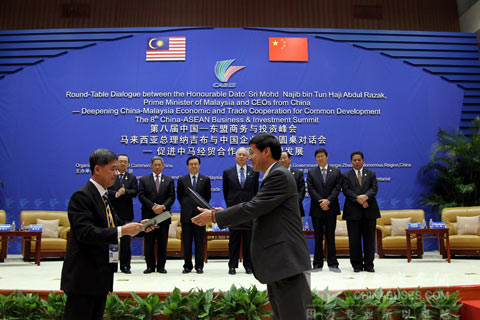 在马来西亚总理纳吉布(后排正中)见证下，大金龙常务副总经理陈志强(右)与马来西亚联合巴士公司执行董事CHEONG KONG FITI(左)签订200辆天然气客车采购意向