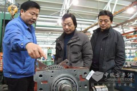 参加鉴定会的重庆恒通客车有限公司总工程师万昶（中）在副总经理刘韶东的陪同下在綦齿总装分厂参观